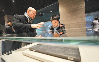 工作人员在向小朋友讲解木雕版孔子圣迹图 （人民视觉 杨国庆摄）