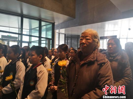 殉难者家属和观众代表向七三一部队殉难者名录献花。　魏来 摄
