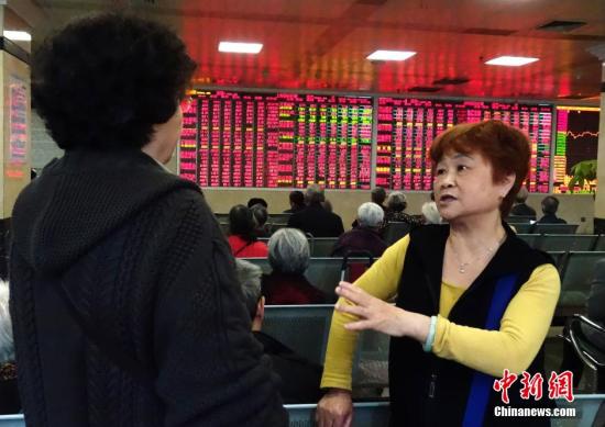 资料图：两位股民正讨论股市走势。<a target='_blank' href='http://www.chinanews.com/'>中新社</a>记者 刘忠俊 摄