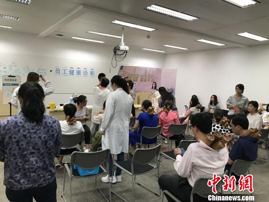 医务人员定期到各个楼宇、大厦送健康。量血压和医疗咨询等服务让白领受益匪浅。　芊烨 摄
