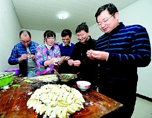     青墩村“第一书记”叶松（右三）、韩桥村“第一书记”任少贤（右二）与“三同”队员及村民在一起包饺子，欢度新年。