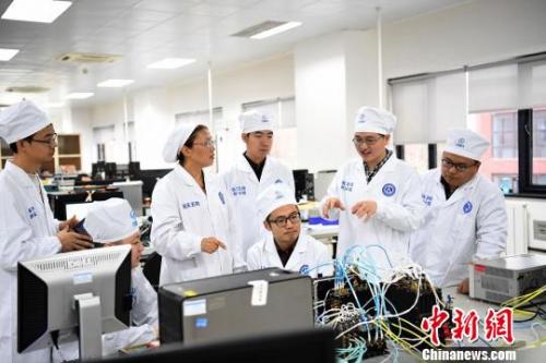 西安分院嫦娥四号探测器的研制人员正在讨论问题。　苏宏伟 摄