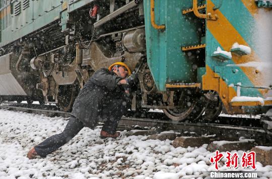 南京东机务段机车乘务员强化雪天机车走行部、车钩等关键部件检查，确保机车质量良好，途中运输安全。　刘金建 摄