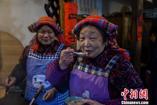 大妈品尝自己亲手熬制的腊八粥。　方华彬 摄