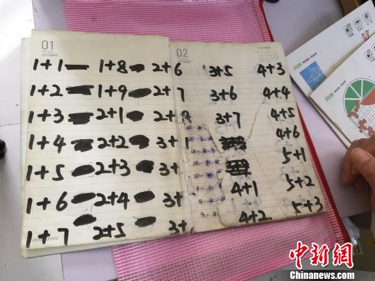 图为孩子们被翻烂的算术本 武一力 摄