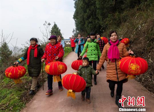 当地村民手拿红灯笼走在回家路上　郑家裕　摄