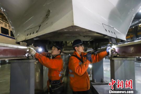动车组机械师正在检查动车组底部组件。　肖尧 摄