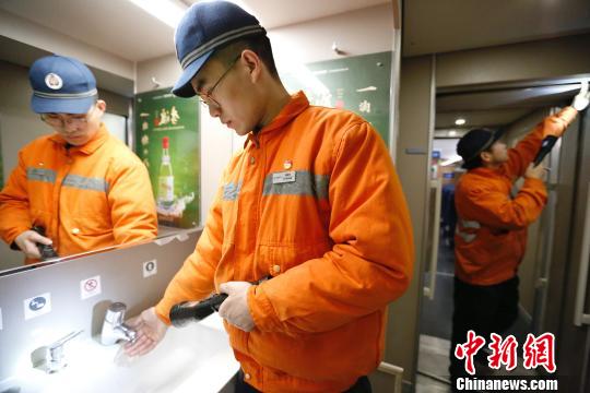 动车机械师正在检查动车组车厢内各旅客服务设备状态是否良好。　丁波 摄