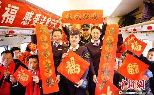 列车员和乘客一起展示春联和福字。　张娅子　摄
