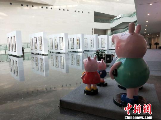 小猪佩奇“一家四口”站立在漫画展的对面，正远远观望着。　杨佩佩 摄
