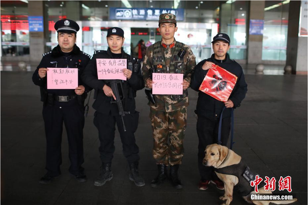 2月1日，随着春节临近，南京铁路公安处南京站派出所的民警在纸上写下“平安春运，有我们护航”、“天下无贼是我们最大的心愿”、“平安归途么么哒”等话语，用别样的方式给旅客们送上温馨的新年祝福。图为南京火车站联勤巡逻队伍送出温馨祝福语。中新社记者 泱波 摄