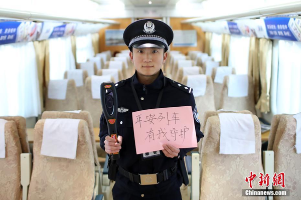 2月1日，随着春节临近，南京铁路公安处南京站派出所的民警在纸上写下“平安春运，有我们护航”、“天下无贼是我们最大的心愿”、“平安归途么么哒”等话语，用别样的方式给旅客们送上温馨的新年祝福。图为执行跟车任务的民警送出温馨祝福语。中新社记者 泱波 摄