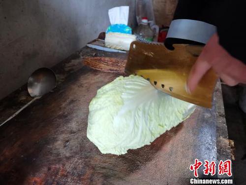 当天中午，刘奉智熟练地切白菜、刷锅、烧油，炖白菜汤，准备午饭。　郝学娟 摄