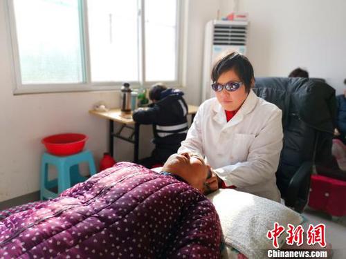 在社区服务中心，刘奉智母亲为村里人按摩，刘奉智在一旁写作业。　郝学娟 摄