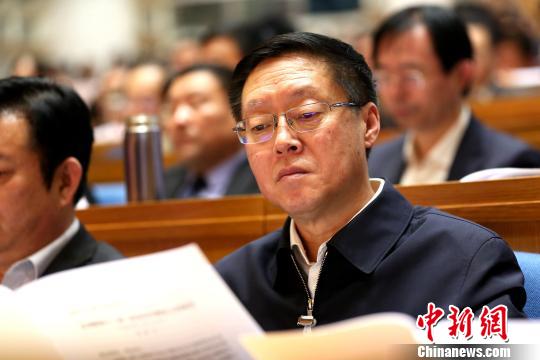 图为与会政协委员在现场阅读会议文件。 梁犇 摄 图为与会政协委员在现场阅读会议文件。 梁犇 摄