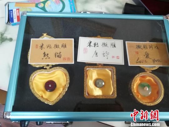 济南微雕非遗传承人王天明将大熊猫、唐诗等微雕在米粒上。　孙婷婷 摄