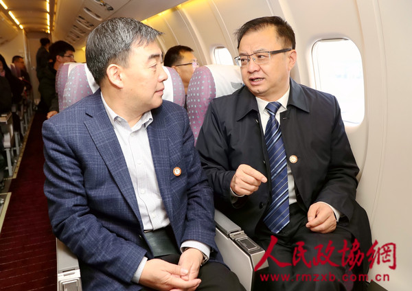 3月1日，住宁全国政协委员乘坐专机前往北京参加全国两会。图为马宗保委员和何晓勇委员就提案的细节进行沟通。本报记者 范文杰 摄_副本