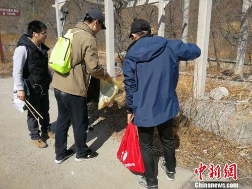 登山队员们一手握夹子、一手拎袋子，开展登山捡拾垃圾活动。招嘉虹/摄 招嘉虹 摄