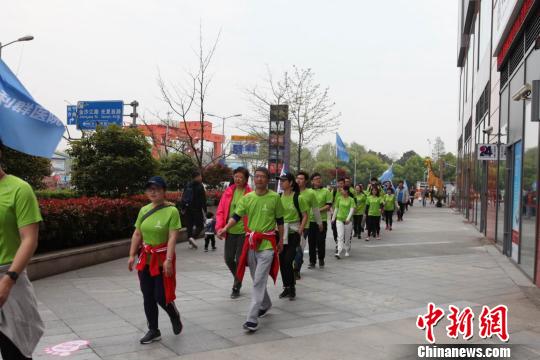 专业教练演示健走的标准姿势及正确的热身方式，并带领参赛人群进行实地健走活动。　陈静 摄