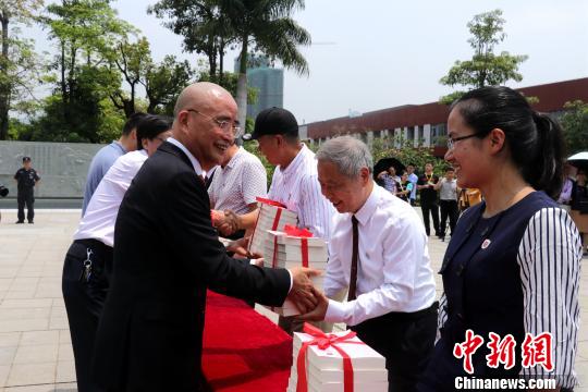 李德文董事长给学校老师赠送《论语新解》。　魏玥 摄