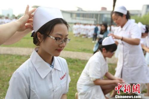 资料图:前辈为医学生戴上护士帽 资料图:前辈为医学生戴上护士帽