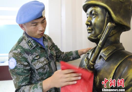 卞龙擦拭申亮亮烈士的雕像。　杨再新 摄