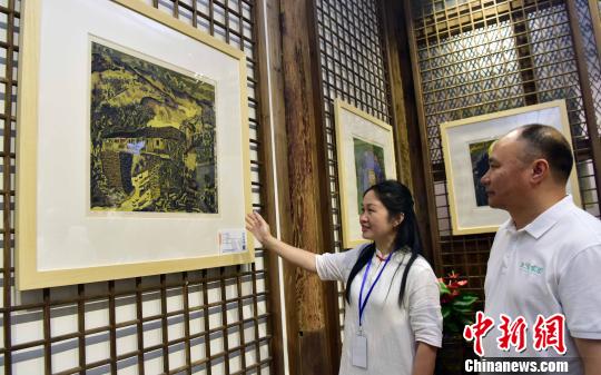 6月12日，松溪版画院院长蔡丽(左)与松溪版画院顾问兰坤发(右)一起欣赏版画作品。　张丽君 摄