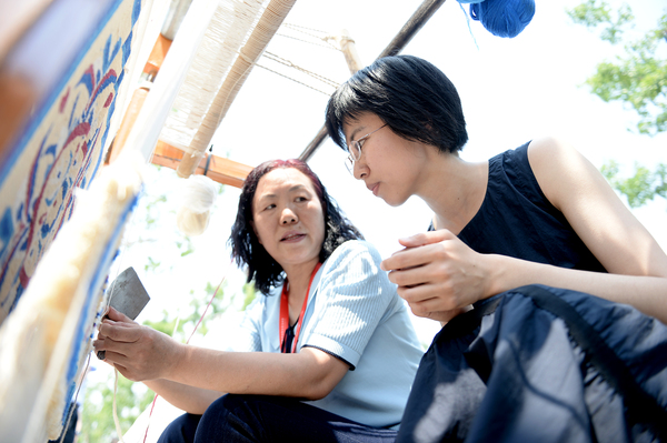 7活动现场，参观者听取牧民讲诉骆驼毛毛毯的纺织技艺