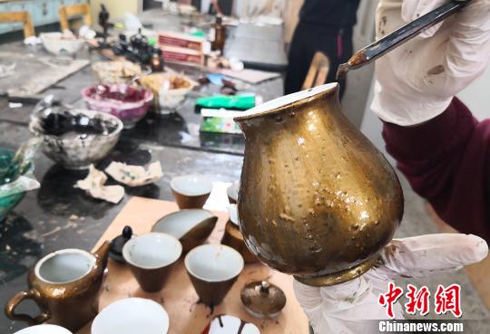 图为学生给茶杯上漆。　刘玉桃 摄