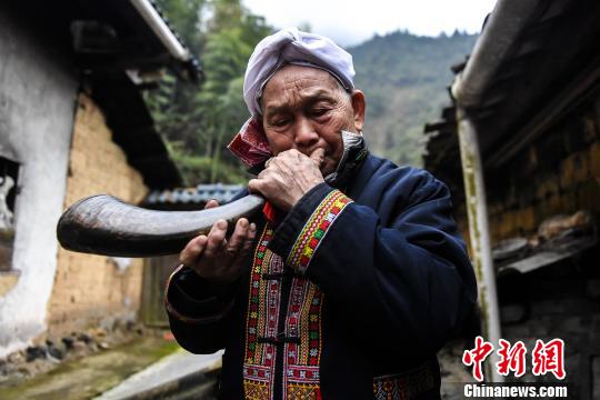 尽管年过八旬，盘良安依旧能吹响牛角迎客。　李凌 摄