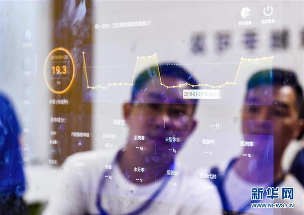 在广东深圳会展中心举办的第七届中国电子信息博览会（CITE2019）上，观众在京东方展台了解智能镜子（2019年4月9日摄）。 新华社记者 毛思倩 摄
