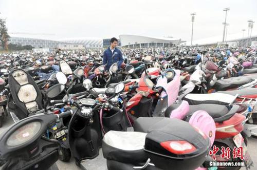 12月14日，福州仓山南二环附近的临时停车场停放超过2.2万辆无牌、超标电动车，场面震撼。福州市交警一个多月来共查处电动车各类交通违法14万多起，暂扣无牌、超标电动车2.2万多辆。图为市民凭有效证件及购车发票领回被扣车辆。<a target='_blank' href='http://www.chinanews.com/'>中新社</a>记者 吕明 摄