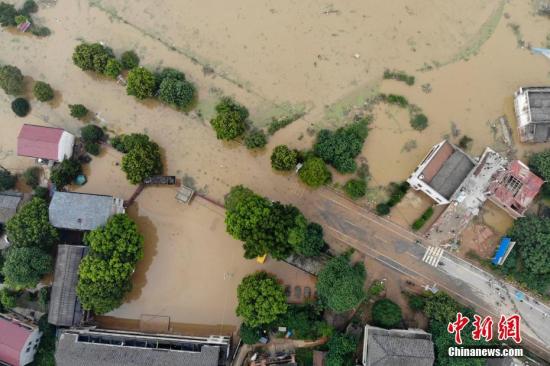 7月11日，湖南衡东县多个乡村与一些道路仍然浸泡在洪水中。连日来，衡东县出现了持续强降雨天气，造成该县17个乡镇、233个村、22个社区普遍受灾。衡东县防汛抗旱指挥部启动防汛Ⅰ级响应急响应。10日，衡东县霞流镇洣河村洣水河堤发生两处漫堤决口，决口宽度分别约为50米和30米，霞流镇第一时间组织附近村民转移。图为衡山县通往衡东县的东健大道被洪水阻断。杨华峰 摄