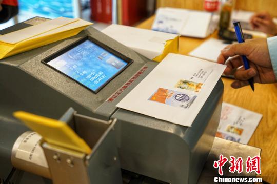 市民等待机器盖邮资机宣传戳。　董翌 摄