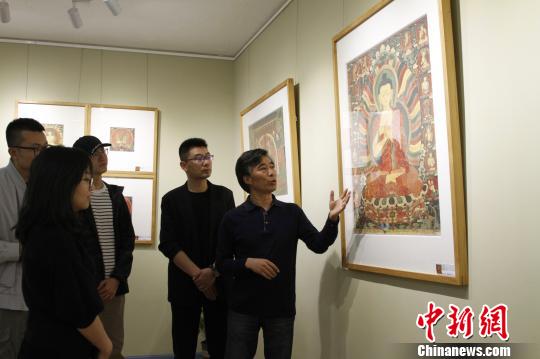 图为主创者高志勇向参观嘉宾介绍拍摄作品。　赵朗 摄