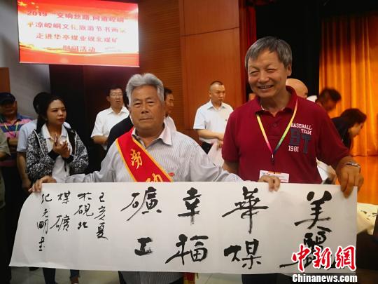 图为书画名家给华亭煤业集团公司全国劳模赠送作品。　魏建军 摄