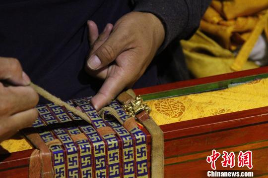 图为罗布林卡管理处工作人员将普查登记完的一函古籍封装。　赵朗 摄