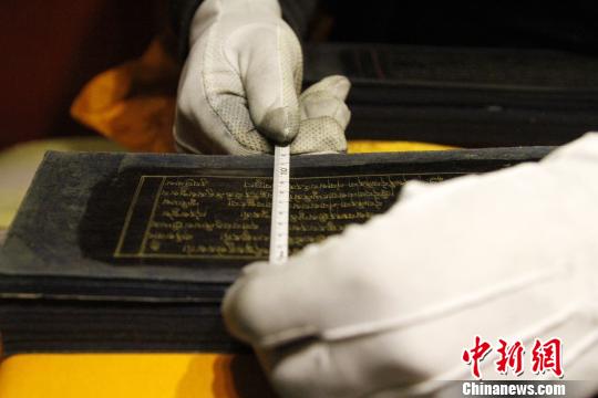图为罗布林卡管理处工作人员测量古籍尺寸。　赵朗 摄