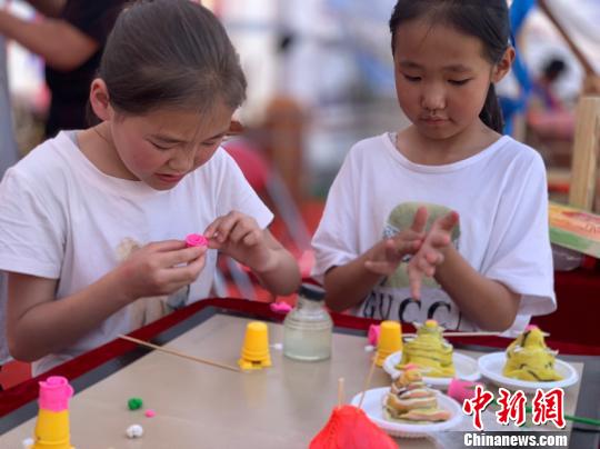 图为两个小女孩正在捏米塑。　孙睿 摄