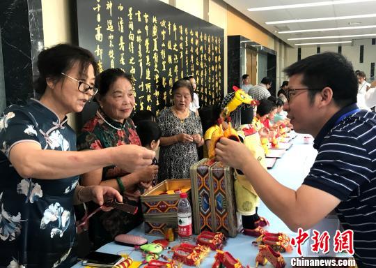 图为“秦观故里”高邮三垛七夕习俗“巧娘娘送巧”——心灵手巧的妇女将自己一针一线手工制作的虎鞋送给孩子。　崔佳明 摄