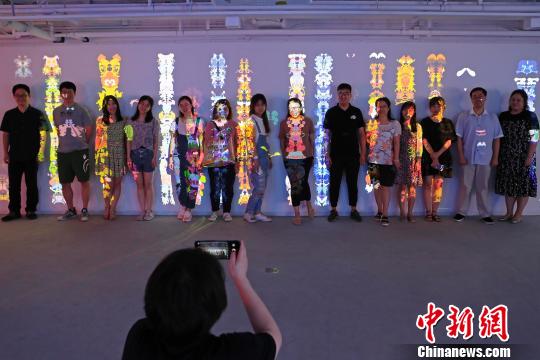 民众在艺术装置前合影留念。　殷立勤 摄
