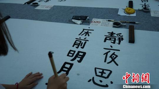 图为中日韩青少年正在用毛笔书写唐诗。　党田野 摄