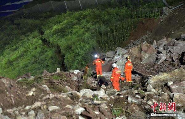 8月15日，四川甘洛，成昆铁路埃岱站区间附近发生的山体垮塌现场，失联人员搜救工作紧张进行。图为垮塌的泥石堆边上，长满植被的山体有一条裂缝。中新社记者 刘忠俊 摄