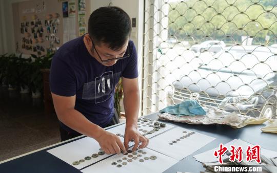 工作人员在研究古钱币“身份”。　杨立超 摄