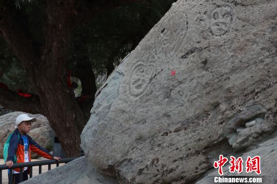 在宁夏贺兰山岩画景区内，这在观看岩画的游客。　于晶 摄