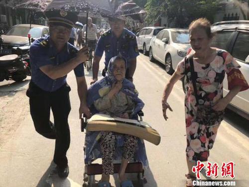 工作人员疏散年长居民。　下宣　摄