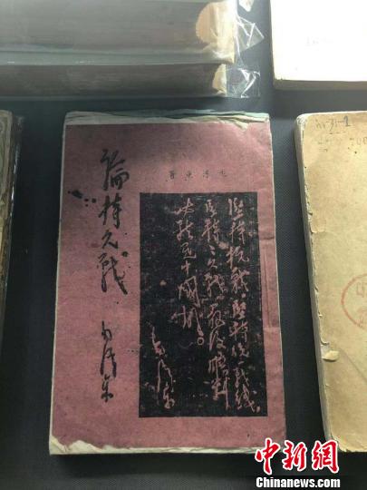一本用白、红、蓝等五种颜色纸张印刷而成的《论持久战》。　李庭耀 摄