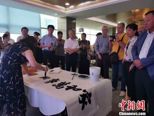 图为，庆祝新中国成立70周年外国专家座谈会暨驻济外国人才中秋节沙龙观上，外国专家观看书法表演。　孙宏瑗 摄