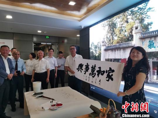 图为，庆祝新中国成立70周年外国专家座谈会暨驻济外国人才中秋节沙龙观上，外国专家展示获赠书法作品。　孙宏瑗 摄