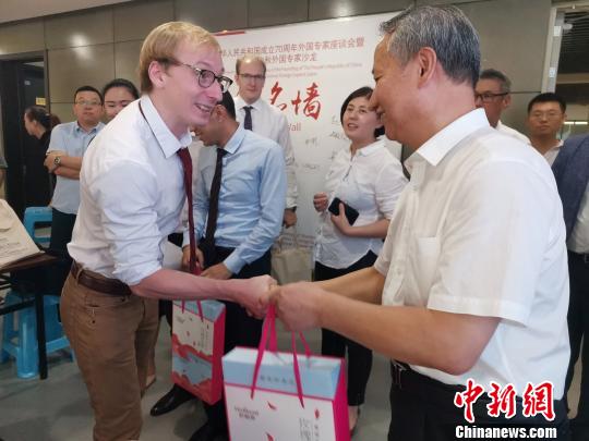 图为，庆祝新中国成立70周年外国专家座谈会暨驻济外国人才中秋节沙龙观上，外国专家获赠中秋月饼。　孙宏瑗 摄